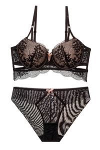 Close-up of black floral lace lingerie set with pink bow detail and jacquard fabric