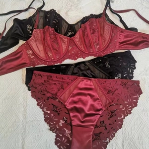 Lace and satin lingerie set in burgundy and black featuring underwire bras and panties