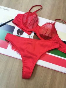 Flat lay of red lace lingerie set with silk details on a professional color card background