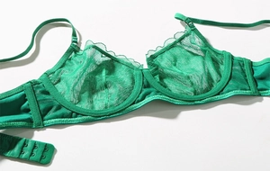 Detailed macro view of vibrant green sheer lace bra fabric with delicate wave edge trim