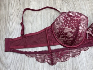 Detailed view of burgundy floral lace bra featuring scalloped edges and tiny bow detail