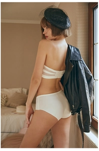 Close-up of seamless white strapless bra with translucent striped back and hook-and-eye closure