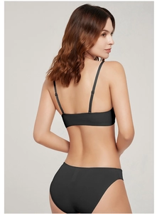 Detail of seamless black lingerie set featuring slim straps and matching briefs on model