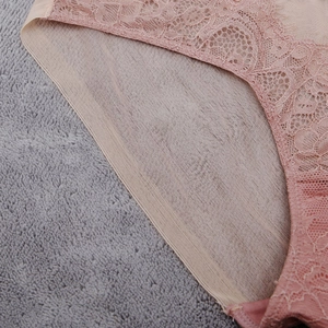 Détail de la dentelle florale et du tissu en maille respirant sur cette culotte rose