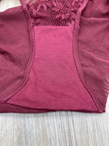 Detail of wine red lace underwear showing intricate floral embroidery and mesh fabric texture