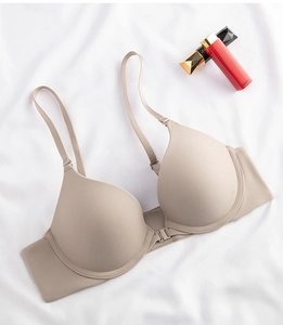 Detailed close-up of seamless front-closure bra with thin straps in a soft beige tone