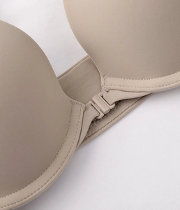 Detailed macro view of the seamless front clasp and smooth matte finish on a beige bra