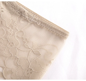 Gros plan du motif dentelle florale délicate sur culotte beige avec bordures ondulées