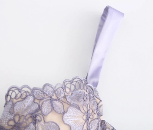 Macro detail of French purple floral lace embroidery and satin strap on bra set