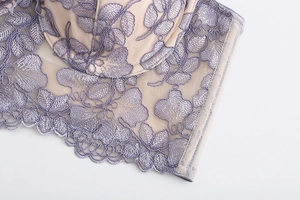Close-up of lavender floral embroidery on beige lace push-up bra with scalloped edges
