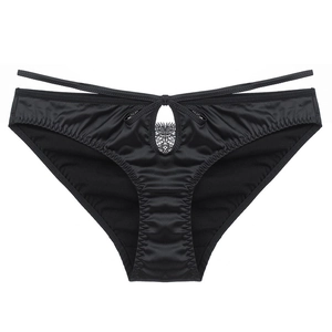 Détail du slip en satin noir avec dentelle ajourée et doubles lanières à la taille