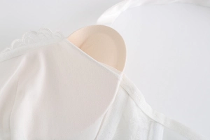 Detail view of white lace bra featuring breathable mesh lining and removable pads