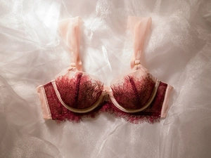 Détail du soutien-gorge en dentelle rouge avec bretelles plissées rose pâle