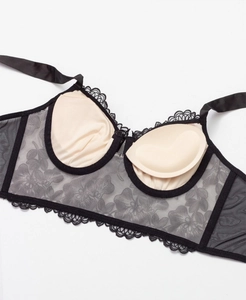 Close-up of black floral embroidery lace and beige padding on a plunge bralette