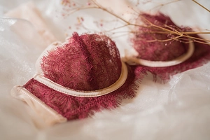 Detail of burgundy eyelash lace bra showing delicate embroidery and underwire design