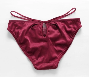 Détail de culotte en satin bordeaux avec découpe au dos et dentelle violette fine