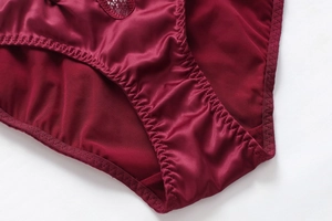 Vue détaillée du satin rouge foncé et de la dentelle délicate sur cette culotte femme