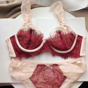 Detailed flat lay of French eyelash lace lingerie set in burgundy with sheer mesh texture