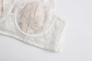 Detail of white French lace bra featuring floral embroidery and soft underwire support