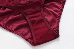 Détails macro d'une culotte en satin bordeaux avec bordure en dentelle florale