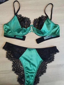 Détail d'un ensemble de lingerie en satin vert menthe et bordure en dentelle noire
