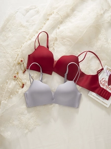 Close-up of seamless wireless bras in burgundy and lilac on lace with pearls