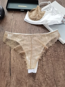 Détail montrant la broderie en dentelle blanche sur un ensemble lingerie de luxe