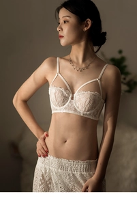 Detail of white French floral lace bra with elegant criss-cross straps on a model