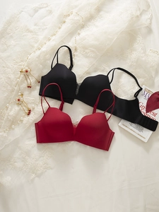 Flat lay of seamless wire-free bras in black and dark red on a lace background