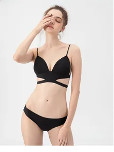 Detail of black seamless backless bra with cross-strap design and matching panty set