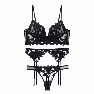Detail view of black floral lace embroidery on sheer mesh lingerie three-piece set