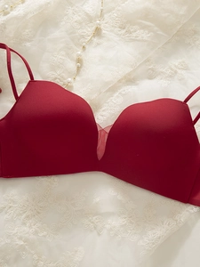 Detail view of wine red seamless wire-free bra with elegant lace and pearl background
