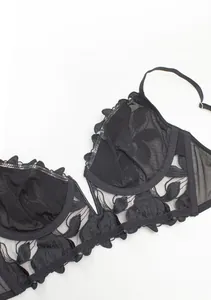 Detail of black floral lace embroidery on thin mesh bra with refined stitching