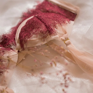 Soutien-gorge en dentelle rouge et mesh rose avec fines bretelles sur fond blanc