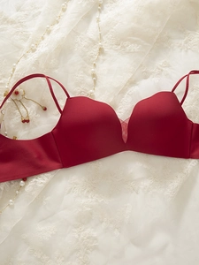 Detail of dark red seamless wireless bra with V-mesh detail on white lace fabric