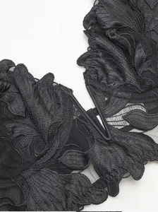 Detail of black floral embroidery lace and V-shaped center gore on a sheer mesh bra