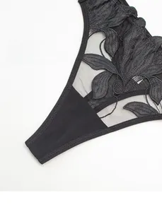 Close-up of black floral lace embroidery and sheer mesh on narrow side lingerie strap