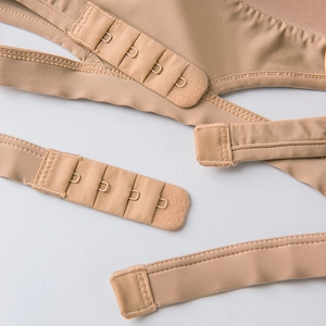 Detail of skin-tone seamless bra strap extension with four-row metal hooks and eyes