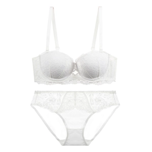 Dettaglio in piano del set reggiseno e slip in pizzo bianco con ricami floreali fini