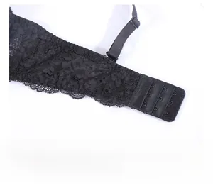 Dettaglio macro del reggiseno in pizzo nero con chiusura sicura a tre file di ganci