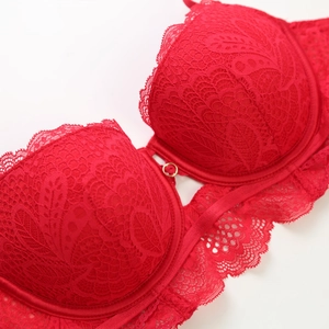 Détail du soutien-gorge en dentelle rouge avec anneau doré et bords festonnés élégants