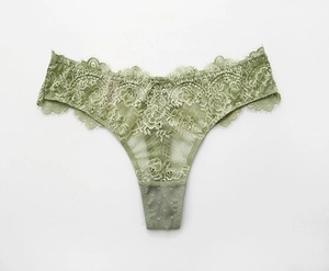 Détail du motif en dentelle florale sur un string vert sauge avec bords festonnés délicats