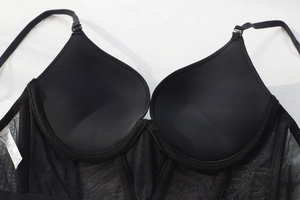 Detail view of black corset bra with mesh wings, boning support and size 75B label