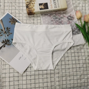 Vue à plat de culottes en coton blanc sans couture avec des accessoires minimalistes