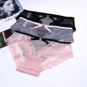 Detailed macro view of three lace panties with heart-shaped metal rings and dotted mesh
