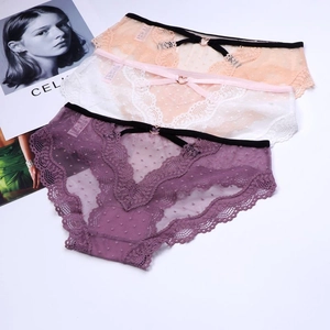 Detail of three-pack lace mesh panties with heart buckle and bow on white background