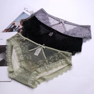 Detailed view of three lace panties in grey, black and green with delicate bow and mesh