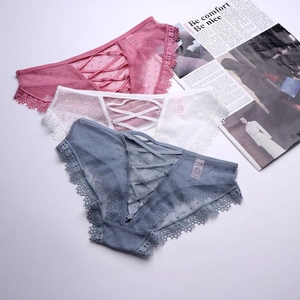 Dettaglio di slip in rete trasparente a pois con pizzo e lacci sul retro