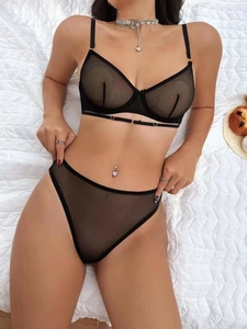 Detailed view of sheer black mesh lingerie set featuring lace-up bra and thong