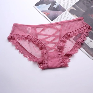 Dettaglio di mutandine in pizzo rosa con design a incrocio e tessuto a rete a pois
